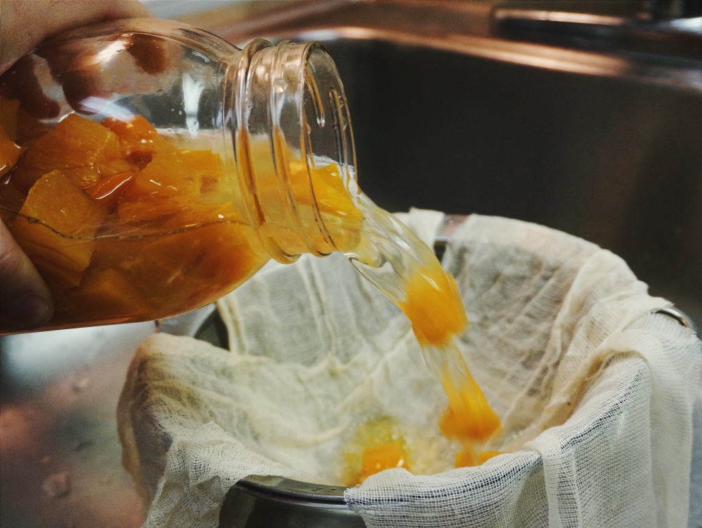 Straining the fruit.  It will smell scarily of vinegar.  Don't be afraid.