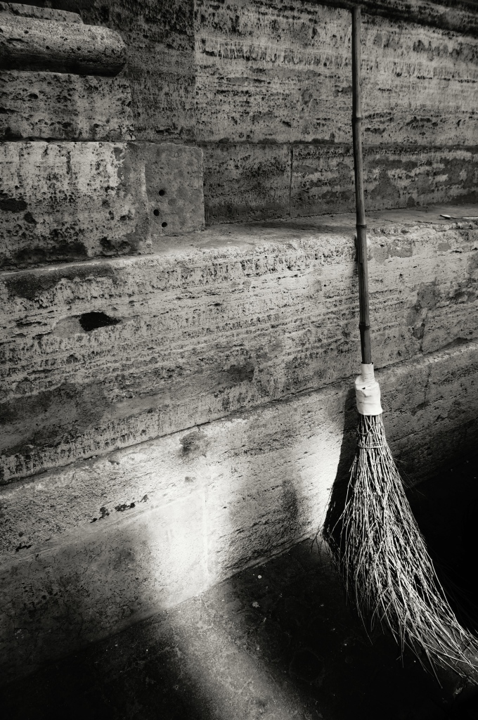 Twig broom leaning on a wall